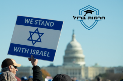 “A person holding a sign with the text ‘WE STAND WITH ISRAEL’ alongside the Star of David, and Hebrew text above it reading ‘מתחייבים ביחד’. The backdrop includes the United States Capitol building.”