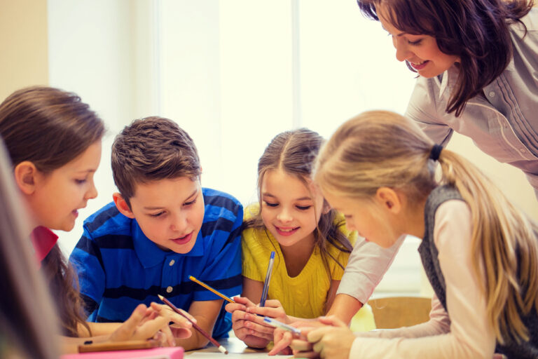 Group of school kids writing test in classroom