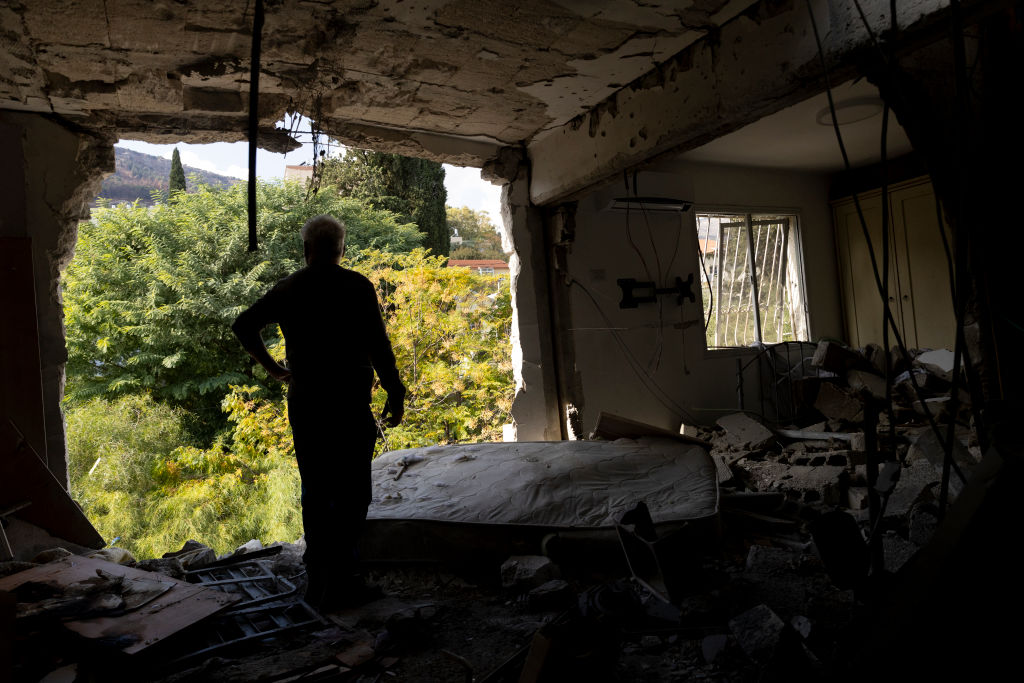 KIRYAT SHMONA, ISRAEL - NOVEMBER 20: Izhak Moyal, a neighbour, inspects a damaged apartment after a rocket strike from Lebanon against the northern city on November 20, 2024 in Kiryat Shmona, Israel. Israeli Army Radio reported that a rocket fired from Lebanon crashed into the building this morning. (Photo by Amir Levy/Getty Images)