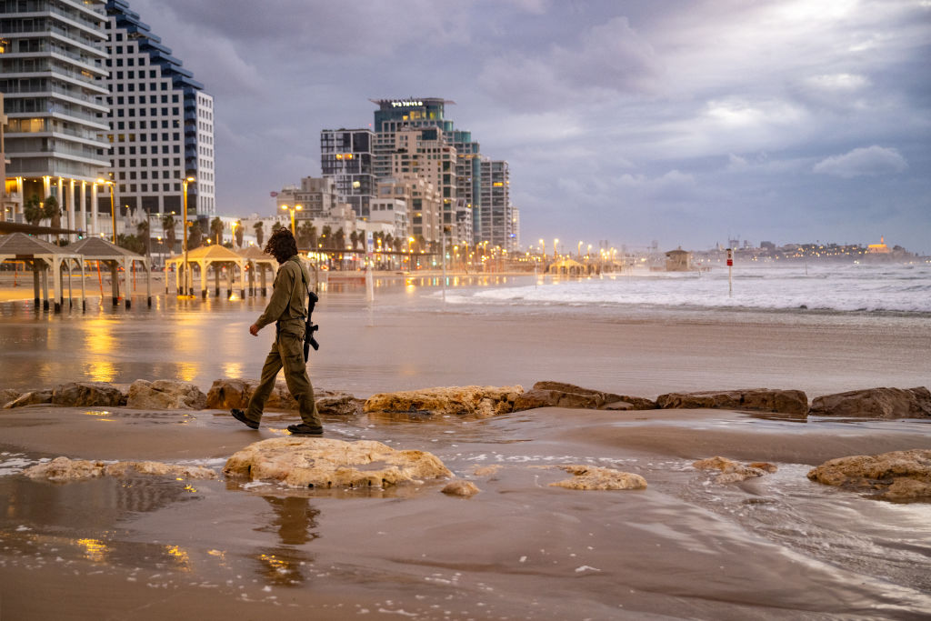 TEL AVIV, ISRAEL - NOVEMBER 27: An IDF reservist walks along the sand at the beach on the fourth day of the temporary truce between Israel and Hamas on November 27, 2023 in Tel Aviv, Israel. A temporary truce between Israel and Hamas began on Friday, followed by the return of some Hamas-held hostages as well as the release of Palestinian prisoners. If the truce holds, around 50 Israeli hostages are to be released, among the approximate 240 that Israeli authorities say Hamas took captive during its Oct. 7 attack. (Photo by Alexi J. Rosenfeld/Getty Images)