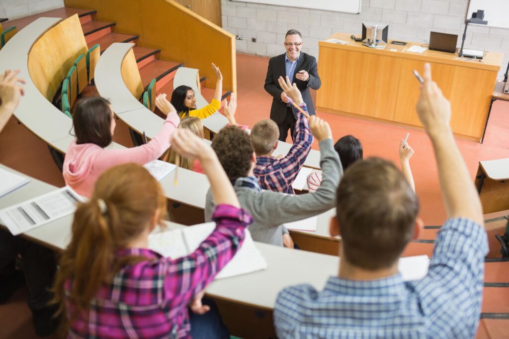 Students raising hands with lecturer