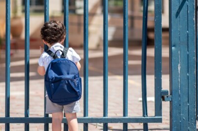 Child with bag back to school. Faceless cute little boy back to school with blue schoolbag.