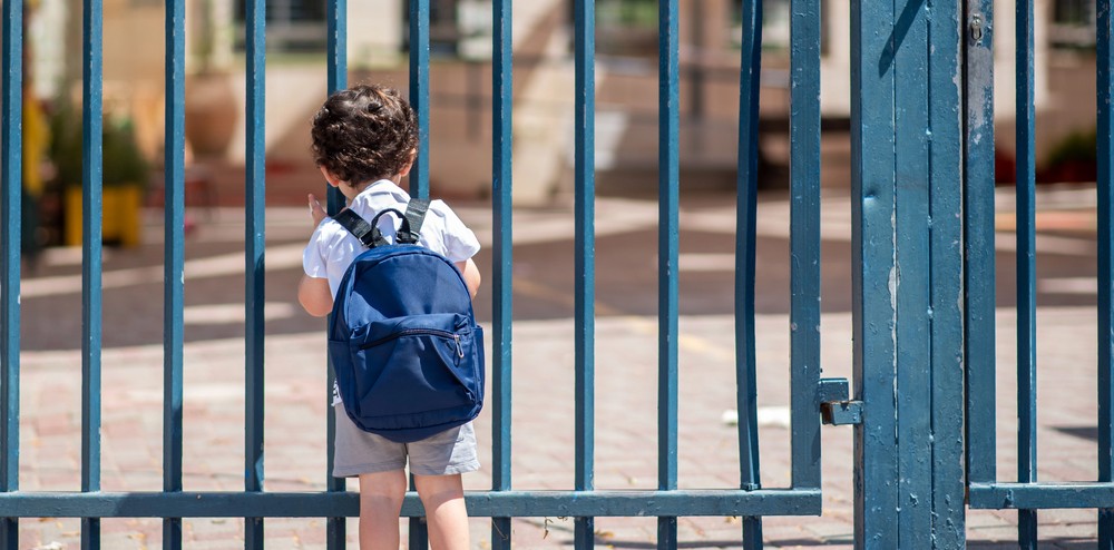 Child with bag back to school. Faceless cute little boy back to school with blue schoolbag.